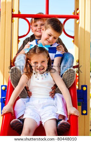 Three little friends on the playground slide