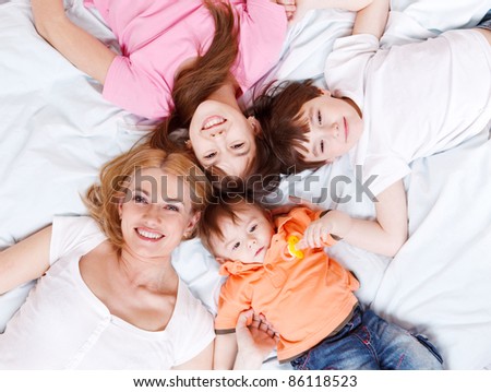 Happy family lying on bed and looking into camera