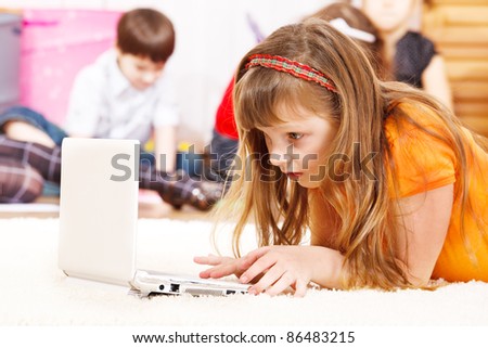 Busy kid lie watching laptop screen