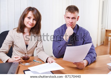 Two colleagues working with papers in the office