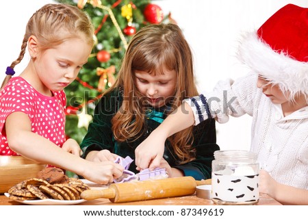 Children cutting Christmas cookies with molds