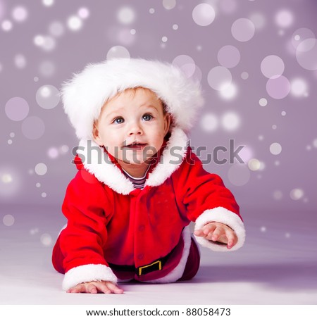 Amazed attractive baby boy in Christmas  costume crawling