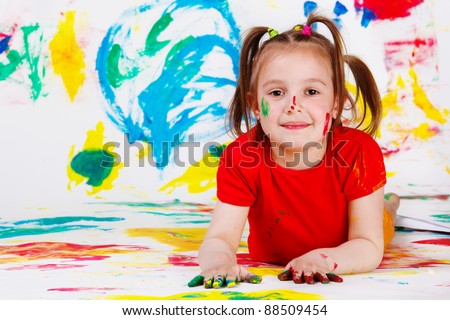 School aged girl in red clothing with her hands and face painted