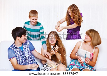 Group of teenage friends throwing pop corn