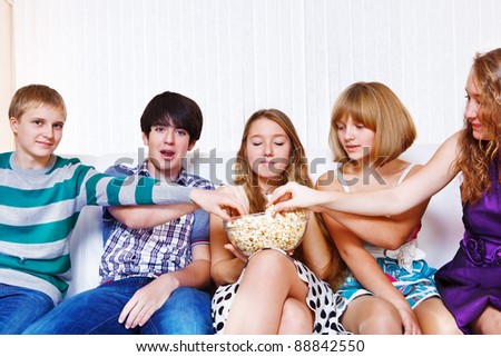 Teenagers group eating popcorn together