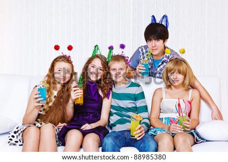 Several laughing young people having cocktail party