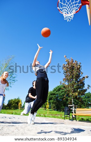 Teenage girl throwing ball to the hoop