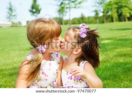 Little sisters kissing each other