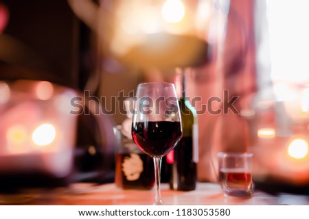 Bartender hands, pours red wine, in glasses, on wooden bar,