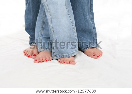 Mother and daughter\'s bare feet and red toenails.