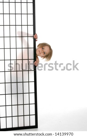 pretty girl peeking out from behind a screen with just her head and fingers showing.
