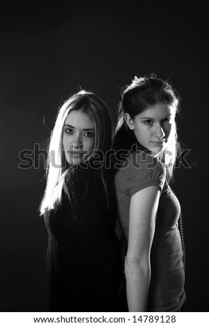 two teenage girls standing back to, in black and white