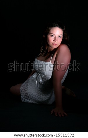young woman sitting with dramatic lighting