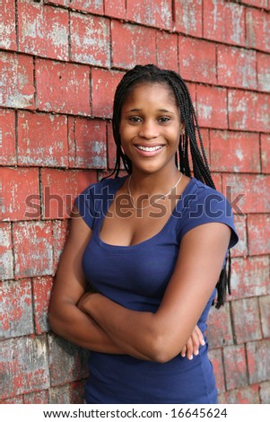 stock photo beautiful black teen next to red weathered shingle siding