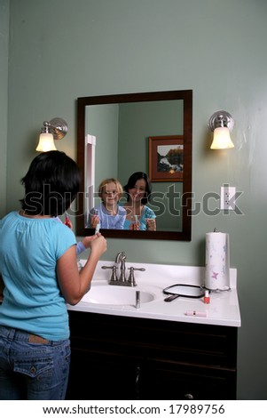 teen and young girl looking into mirror with makeup