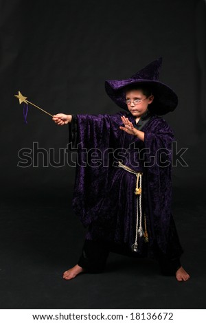 wizard boy in purple velvet hat and robe holding wand and casting a spell