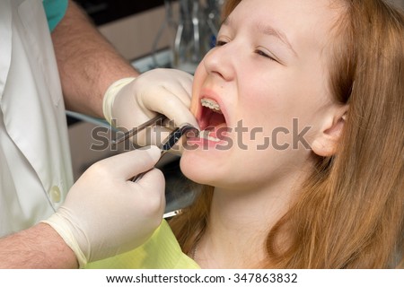 girl in the dentist\'s chair with braces