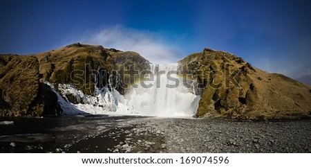 Skogafoss, Iceland, famous waterfall with rainbow covered with ice
