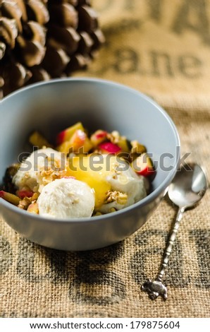 Bowl of yogurt; cut fruits and honey by spoon on sack