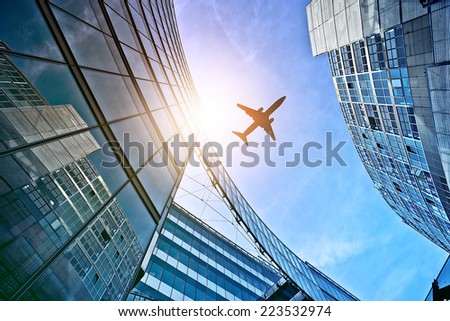 plane flying over modern glass and steel office buildings near Potsdamer Platz, Berlin, Germany