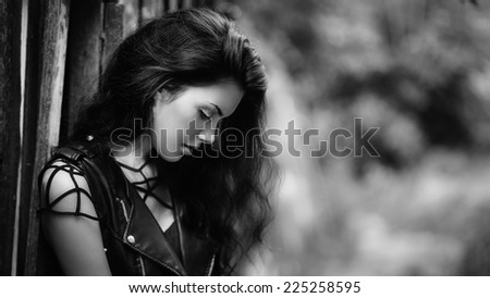 Art portrait of young gorgeous brunette outdoors. Shallow depth of field. Black and white