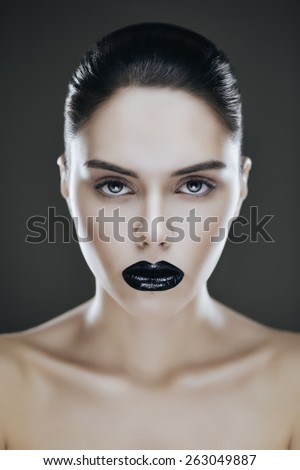 Fashion portrait of young brunette woman with black lips. Shallow depth of field
