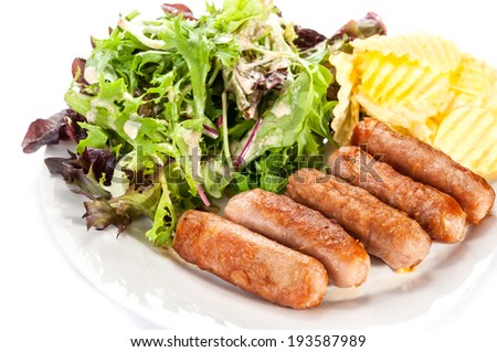 Grilled sausages  vegetables and chips on plate