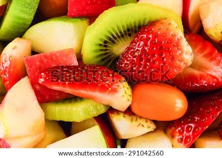 Top view of a fruit salad with strawberries, apple, kiwi for background