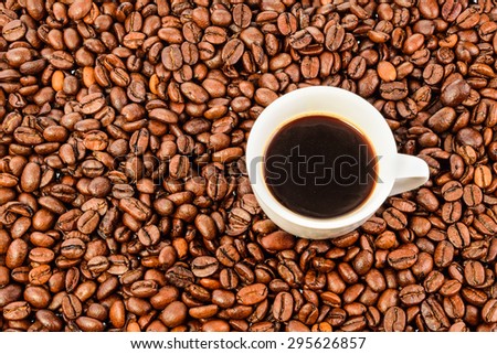 Roasted coffee beans and a cup of coffee, can be used as a background, texture