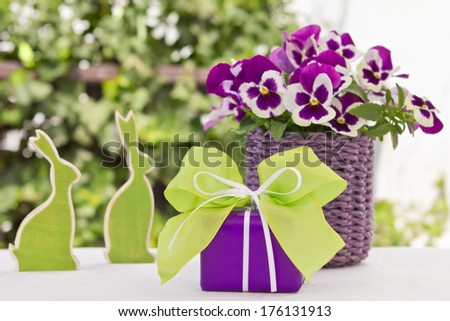 Easter present with bunnies and pansy bouquet in green and purple