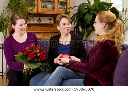 Mother being happy about a gift and a bouquet of red roses on mothers day