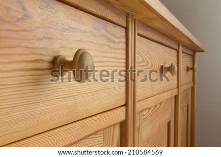 Three drawers of a chest of drawers with knobs, soft wood, tidiness