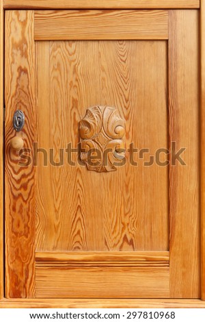 Old pine door with knob, keyhole, key and a wooden ornament, vintage, monochrome