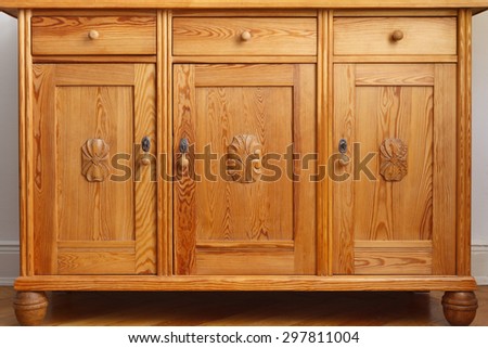 Vintage pine sideboard or cabinet with 3 drawers and three doors with wooden carvings, monochrome