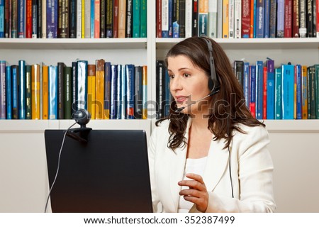 Teacher or tutor of a distance university giving an online lecture or webinar her office, mooc