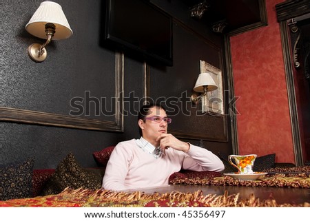 Successful young man sitting in luxury interior