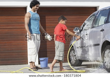Father and son washing the car at home garage