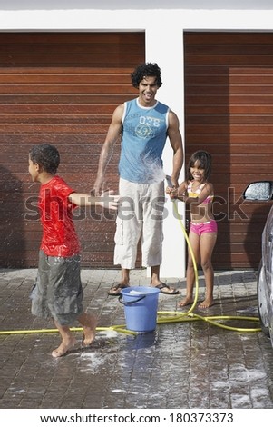 Father and kids washing car