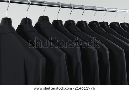 Row of suit jackets on hanger on white background