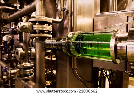 Manipulated picture of a factory showing a green fluid in side of a glass recipe