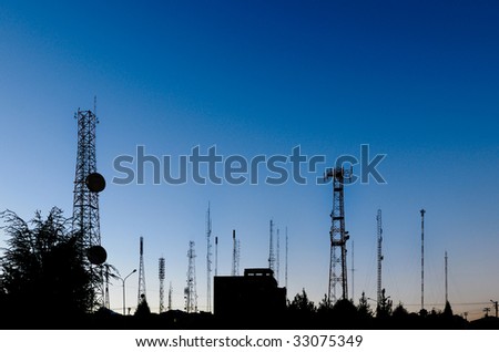 Landscape showing broadcasting antennas at sunset with an intense blue to grey gradient
