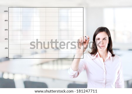 Young business woman drawing on empty graph. Office background.