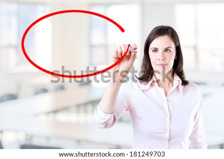 Young businesswoman writing on glass board or working with virtual screen 4. Office background.