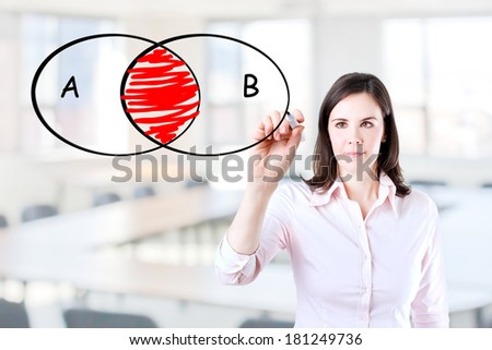 Young businesswoman drawing intersected circle diagram on whiteboard. Office background.