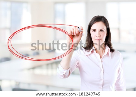 Young businesswoman writing on glass board or working with virtual screen 3. Office background.