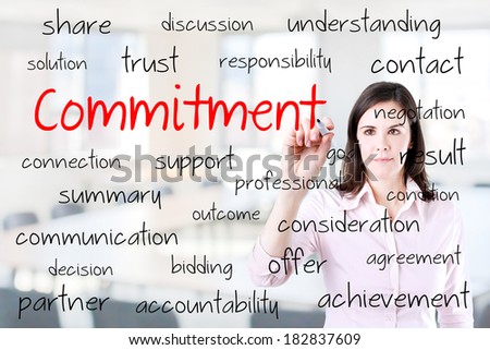 Young business woman writing commitment concept. Office background.