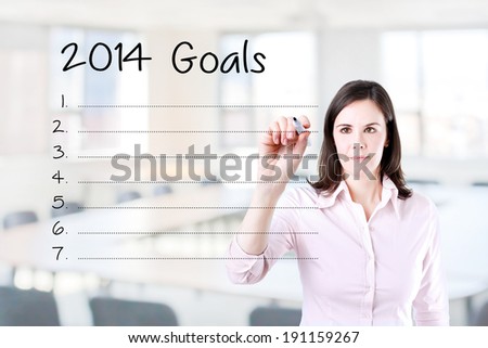 Business woman writing blank 2014 goals list. Office background.