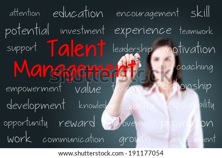 Business woman writing talent management concept. Blue background.