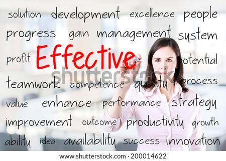 Young business woman writing effective concept. Office background.