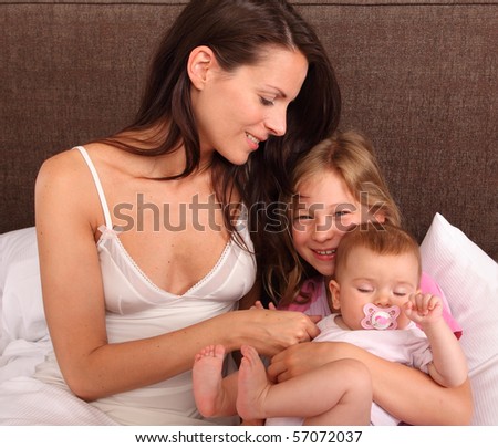 mother daughter and baby in bed- family lifestyle